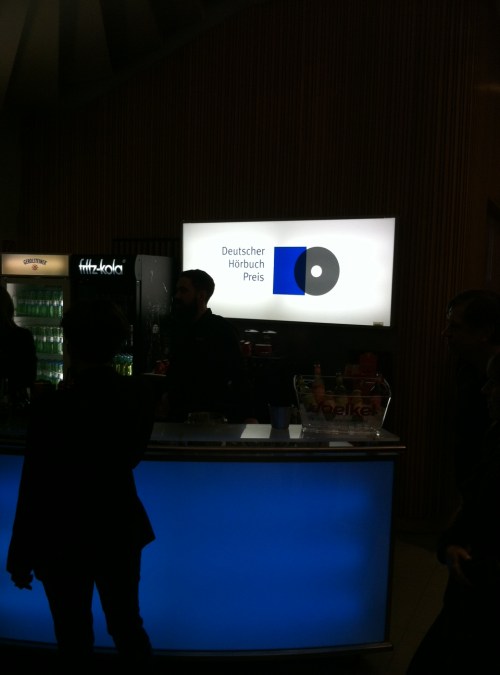 Logo Deutscher Hörbuchpreis über der abgedunkelten Bar im Foyer